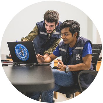 Two male WHO staff looking at a computer.